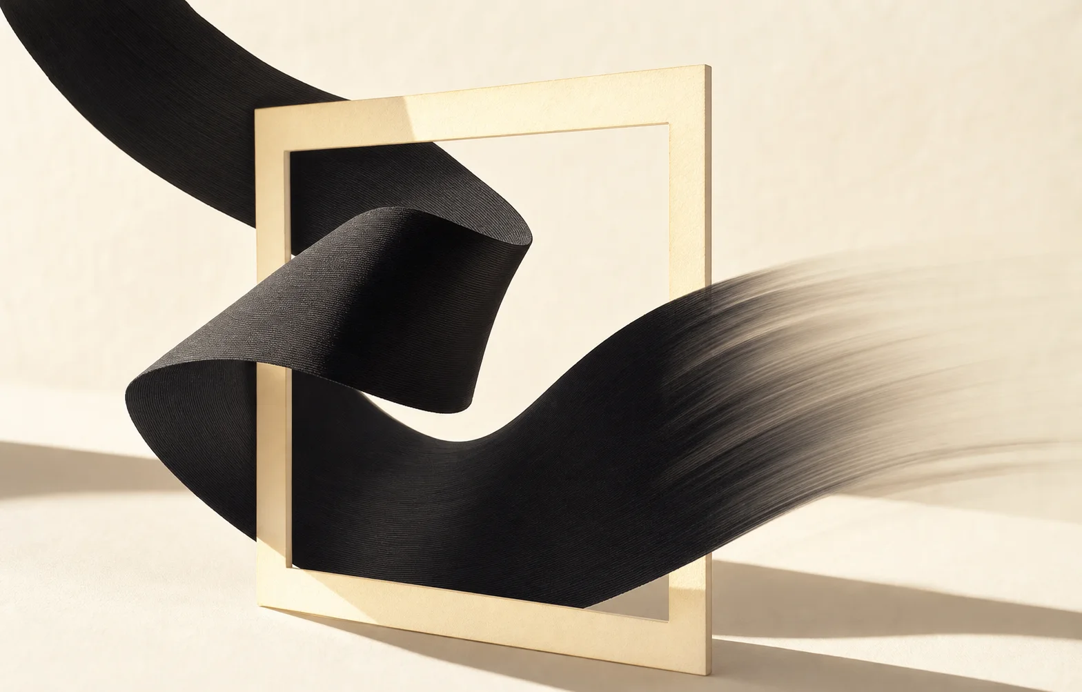 Black ribbon passing through a pale rectangular sculptural frame